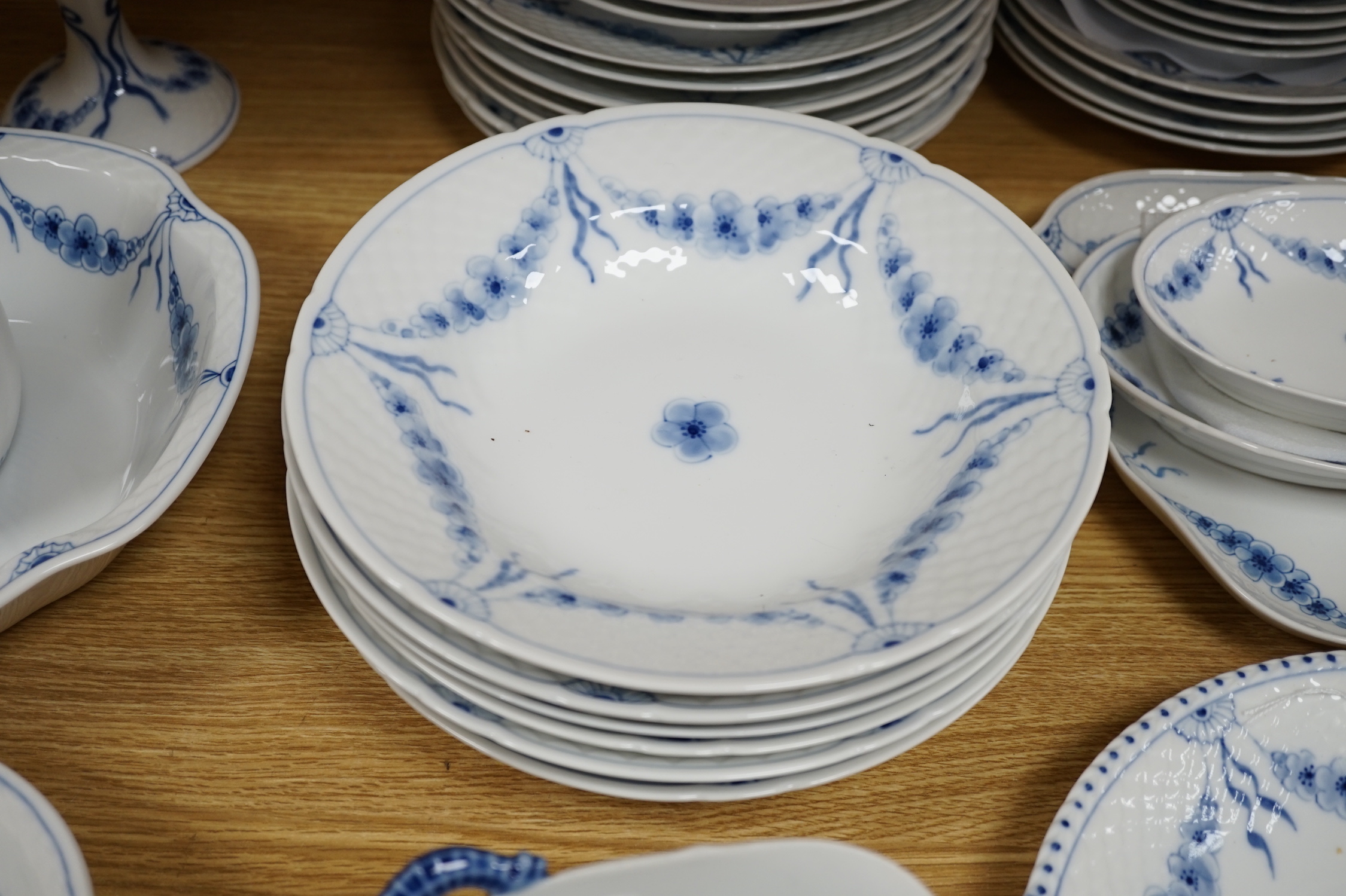 A Bing and Grondahl, Denmark blue and white ‘Empire’ pattern dinner service, thirty-eight pieces including; a cake, stand, candlestick, dinner, plates, jug, serving, dishes, etc.